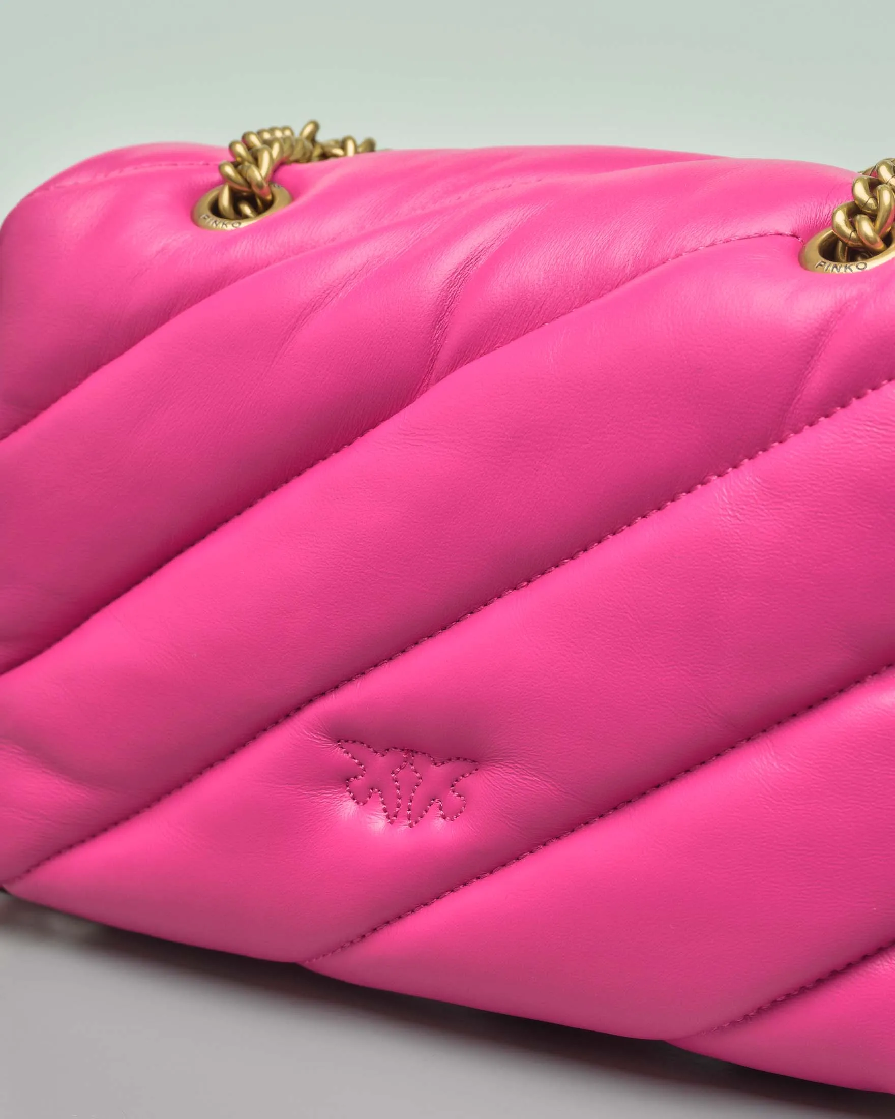 Mini Love Bag Puff fucsia in nappa con motivo matelassè obliquo e fibbi dorata Love Birds